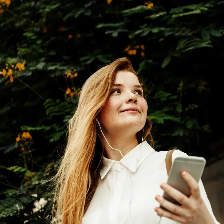 Chica usando su celular al aire libre